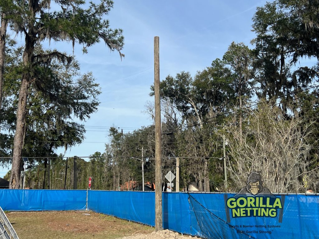 Pole setting for a soccer backstop system.
