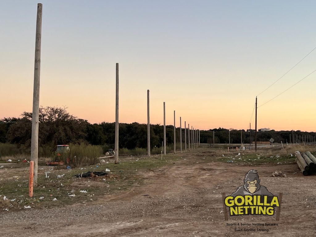 Poles after they were set for a landfill debris netting system.