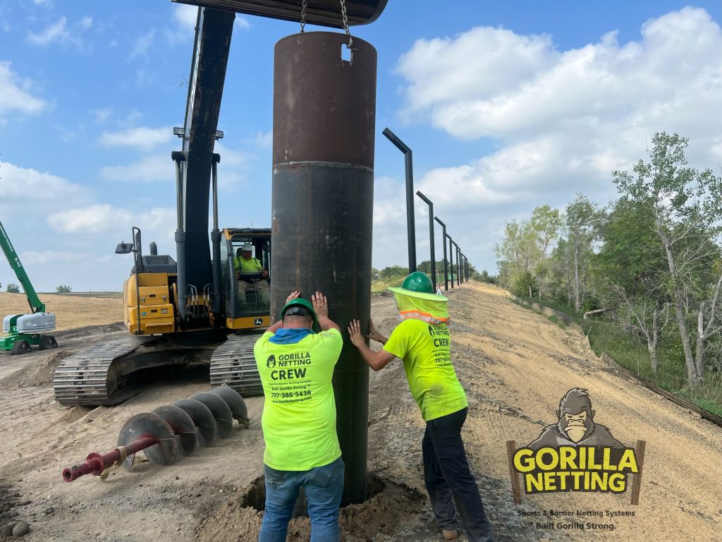 Caissons being set before poles are installed for a litter control fence.