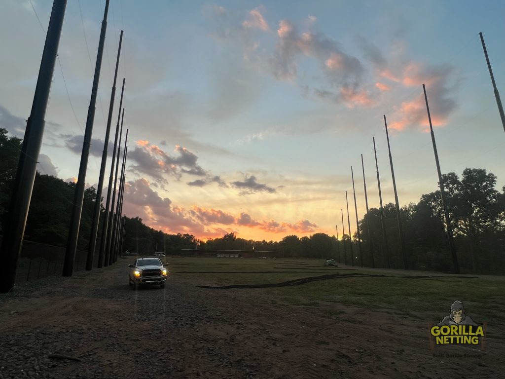 Staged poles installed for a driving range netting system.